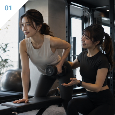 トレーナーからマンツーマン指導を受ける女性